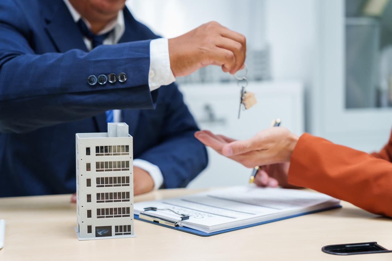 lavinia properties businessman desk in a sales office sells a condo building customer.They agree to sign a contract